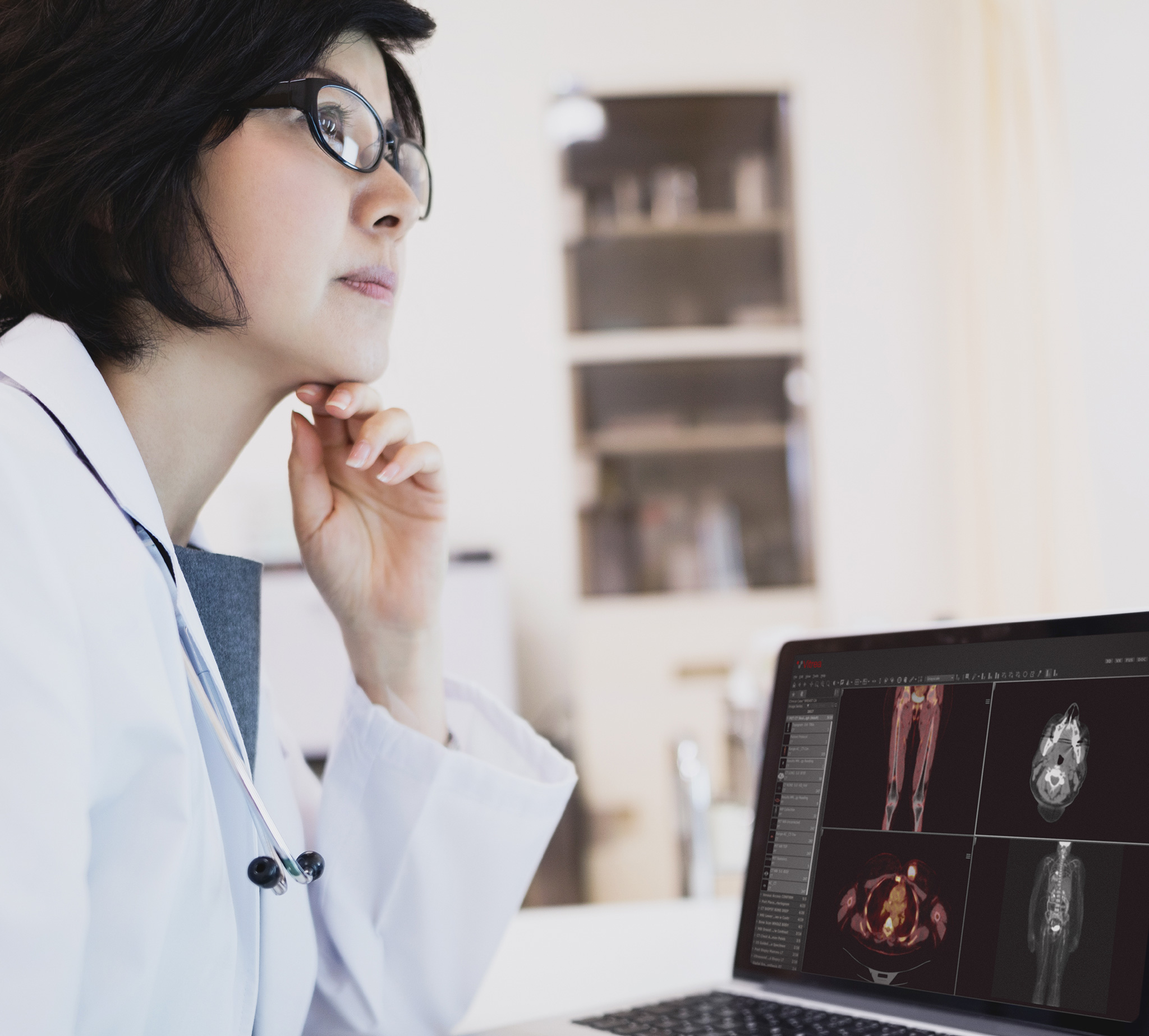 Doctor viewing diagnostic images on laptop.